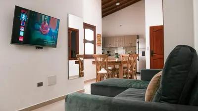 a living room with a couch and a tv on a wall at OCASSO JARDIN APARTAMENTO GALLITO DE ROCA in Jardin