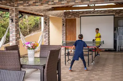 two boys playing ping pong on a ping pong table at Finca Villa Isanella, Santuario, Antioquia in Santuario
