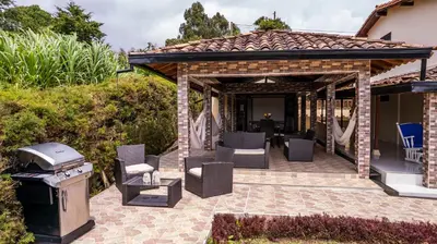 a pavilion with chairs and a grill on a patio at Finca Villa Isanella, Santuario, Antioquia in Santuario