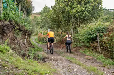 two people riding bikes down a dirt road at Finca Villa Isanella, Santuario, Antioquia in Santuario