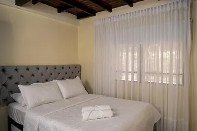 a bedroom with a large white bed with a window at Finca Villa Isanella, Santuario, Antioquia in Santuario