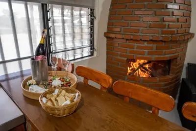 a table with a bottle of wine and a fireplace at Finca Villa Isanella, Santuario, Antioquia in Santuario