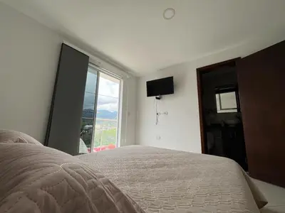 a bedroom with a bed and a large window at Penthouse San Rafael in San Rafael