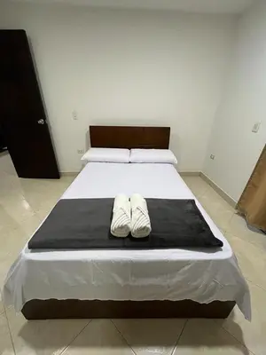 a bed with two white shoes sitting on top of it at Penthouse San Rafael in San Rafael