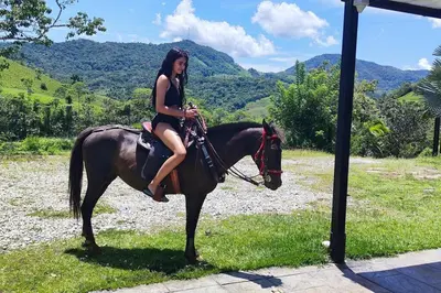 a woman is sitting on a horse at Eco Cabaña San Carlos Ant in San Carlos
