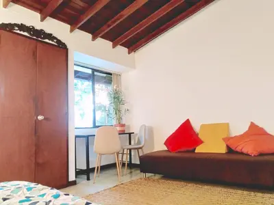 a bedroom with a bed and a table with chairs at Hostal Saveva Para Grupos Familias Estudiantes y Deportistas in Medellín
