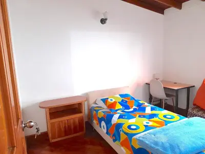 a small bedroom with a bed and a table at Hostal Saveva Para Grupos Familias Estudiantes y Deportistas in Medellín