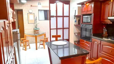 a kitchen with a counter and a table in it at Hostal Saveva Para Grupos Familias Estudiantes y Deportistas in Medellín