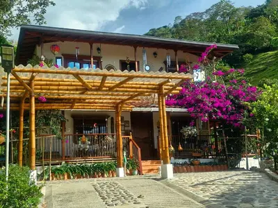 a house with a wooden pergola and flowers at PaloSanto, Casa Rural in Jardin