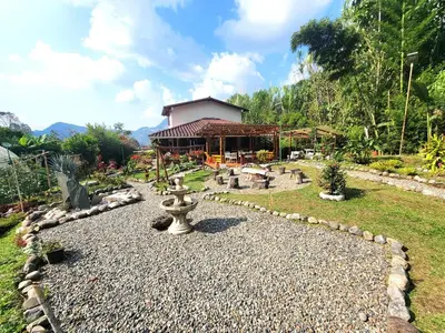 a garden with a fountain in front of a building at PaloSanto, Casa Rural in Jardin