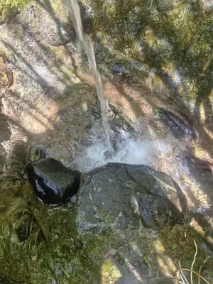 a stream of water rushing over a rock in a river at PaloSanto, Casa Rural in Jardin
