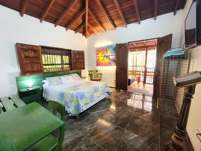 a bedroom with a bed and a table and chairs at PaloSanto, Casa Rural in Jardin