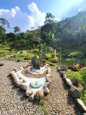 a garden with a fountain in the middle of a river at PaloSanto, Casa Rural in Jardin