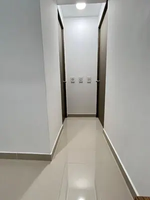 a corridor with white walls and a door in a building at Ubicación Perfecta en Laureles y Confort Total in Medellín