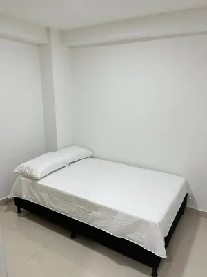a white bedroom with a bed with white sheets and pillows at Ubicación Perfecta en Laureles y Confort Total in Medellín