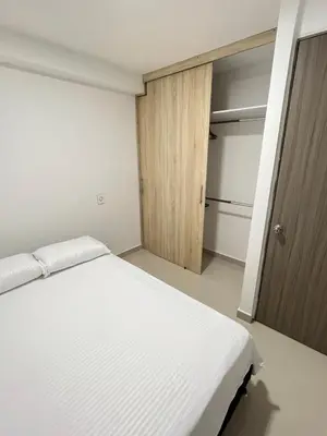 a bedroom with a white bed and a closet at Ubicación Perfecta en Laureles y Confort Total in Medellín