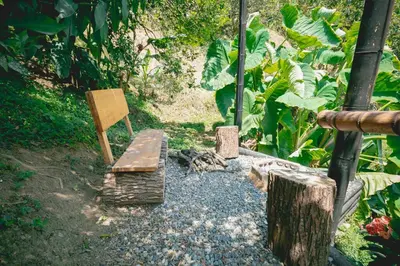 a garden with a wooden bench and a sign at Cabaña / hotel campestre en Manizales para pareja in Manizales