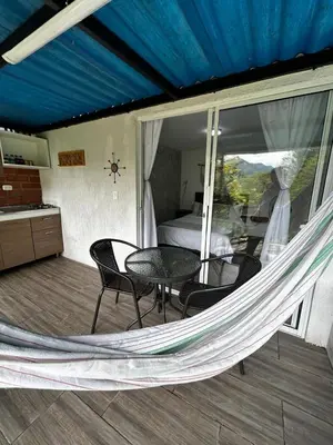a hammock in a room with a bed and a bedroom at Cabaña / hotel campestre en Manizales para pareja in Manizales