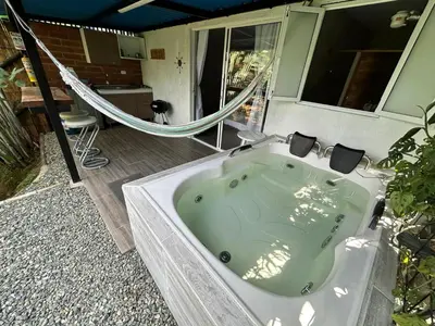 a bath tub with a hammock in a bathroom at Cabaña / hotel campestre en Manizales para pareja in Manizales