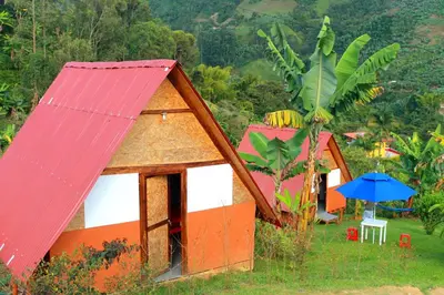 a group of houses with a red roof and an umbrella at Cabañas Villa Loe in Jardin