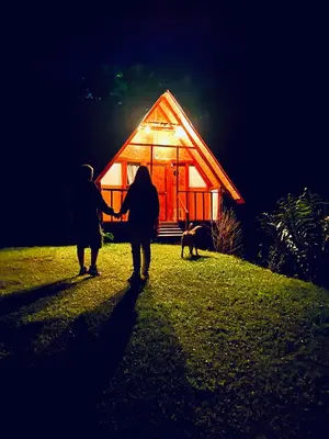 two people are holding hands in front of a cabin at Cabañas Villa Loe in Jardin
