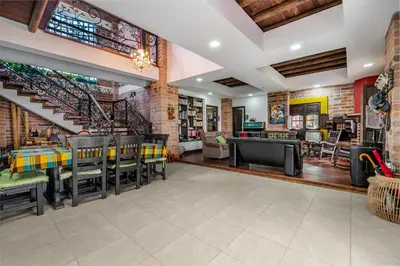 a dining room with tables and chairs and a staircase at AEROPUERTO-Rionegro- MONTEOLIVO COLONIAL in Rionegro