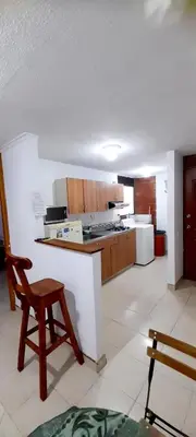 a kitchen with a counter and a chair in it at apartamento centro de la ciudad in Medellín
