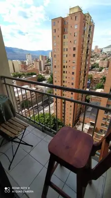 a chair on a balcony with a view of a city at apartamento centro de la ciudad in Medellín