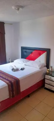 a bedroom with a large bed with a red headboard at apartamento centro de la ciudad in Medellín