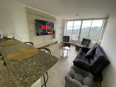 a living room with a tv and a couch and a table at Apartamento Mirador De Castilla in Manizales