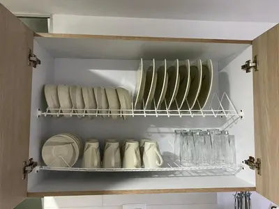 a cupboard with plates and glasses on a shelf at Apartamento Mirador De Castilla in Manizales