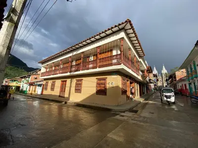 a building with a balcony on the side of a street at HOSTAL LA CASA DE LOS SUEÑOS in Jardin