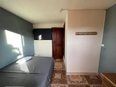 a small bedroom with a bed and a door at HOSTAL LA CASA DE LOS SUEÑOS in Jardin