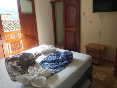 a bedroom with a bed with towels and a window at HOSTAL LA CASA DE LOS SUEÑOS in Jardin