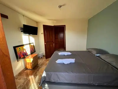 a bedroom with a bed with two towels on it at HOSTAL LA CASA DE LOS SUEÑOS in Jardin