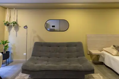 a living room with a couch and a mirror at Apartamento Tranvía 210 in Medellín