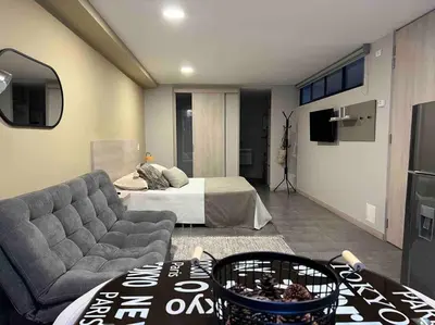 a living room with a couch and a bed at Apartamento Tranvía 210 in Medellín