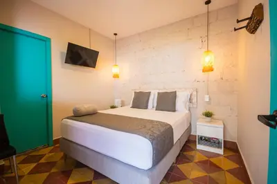 a bedroom with a large bed and a green door at CASA HOTEL LAS HORTENSIAS in Jardin