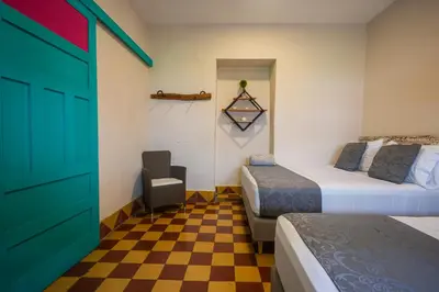 a room with two beds and a checkered floor at CASA HOTEL LAS HORTENSIAS in Jardin