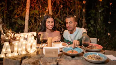 a man and a woman sitting at a table with food at Cabañas para parejas cerca a Medellín - LUUM By Roots Rentals in Marinilla