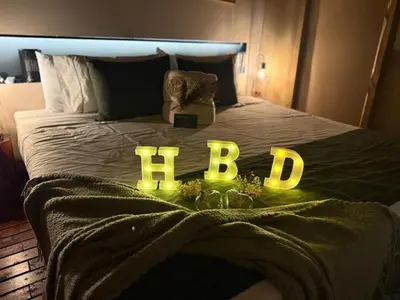 a bed with the word bed spelled out in green lights at Cabañas para parejas cerca a Medellín - LUUM By Roots Rentals in Marinilla