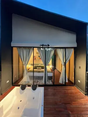 a bath tub with a view of a bedroom at Cabañas para parejas cerca a Medellín - LUUM By Roots Rentals in Marinilla