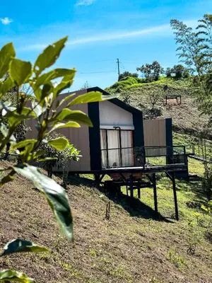 a small house sitting on top of a hill at Cabañas para parejas cerca a Medellín - LUUM By Roots Rentals in Marinilla