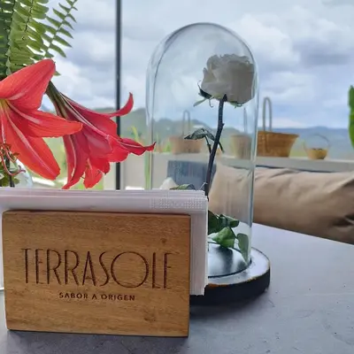 a flower in a glass dome next to a sign at Cabañas para parejas cerca a Medellín - LUUM By Roots Rentals in Marinilla