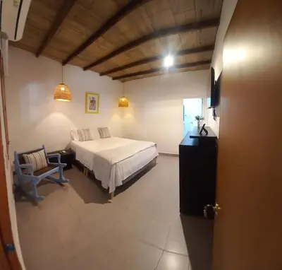 a bedroom with a bed and a chair in a room at casa lumka hotel boutique spa in Mariquita