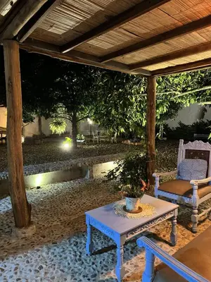 a patio with a table and two chairs under a pergola at casa lumka hotel boutique spa in Mariquita