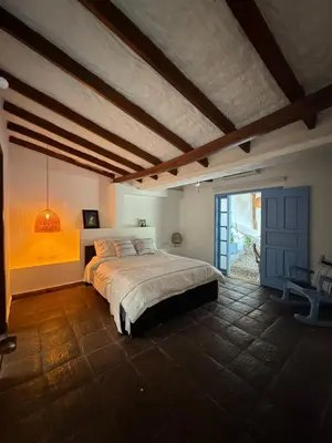 a bedroom with a large bed and a large window at casa lumka hotel boutique spa in Mariquita