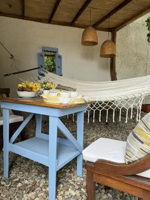 a blue table with a bowl of fruit and a hammock at casa lumka hotel boutique spa in Mariquita