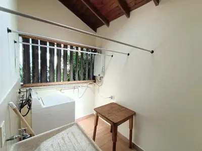 a bathroom with a window and a washing machine and a table at Casa Campestre 1 Nivel para 9H , Poblado San Lucas 110 in Medellín