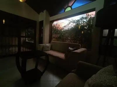 a living room with a couch and a large window at Casa Campestre 1 Nivel para 9H , Poblado San Lucas 110 in Medellín